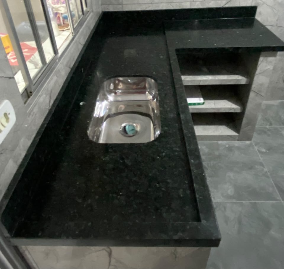 Bancada de cozinha em granito preto em formato de L com cuba de inox