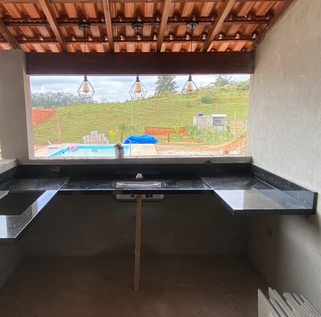 Bancada em granito instalada em área gourmet com vista para o campo